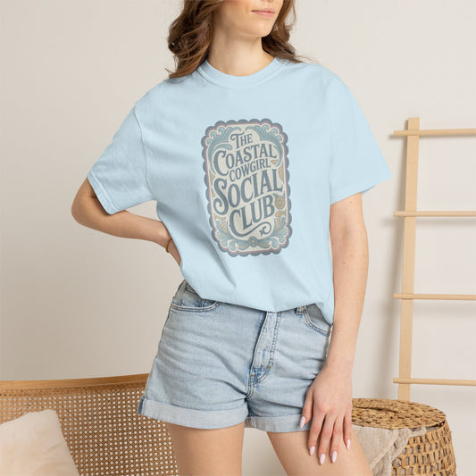 Coastal Cowgirl Clubhouse tee with vintage western sign print and retro coastal colours on model in chambray
