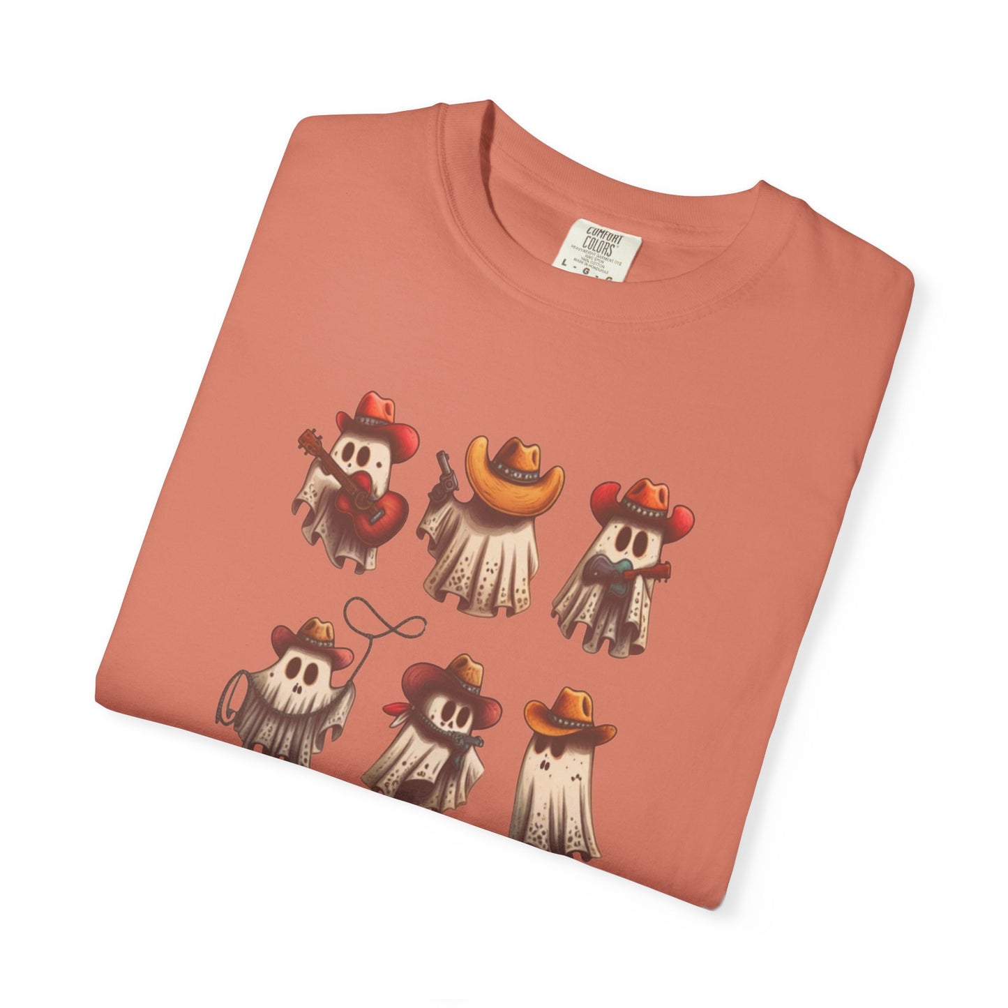 A folded peach-colored t-shirt with a graphic print of six cartoon ghosts dressed as cowboys, displayed on a clean white background.