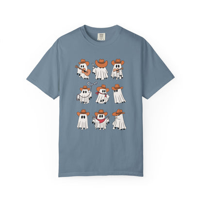 A dusty blue short-sleeve crewneck t-shirt featuring a graphic print of nine cartoon ghosts in cowboy outfits arranged in a 3x3 grid on the front.