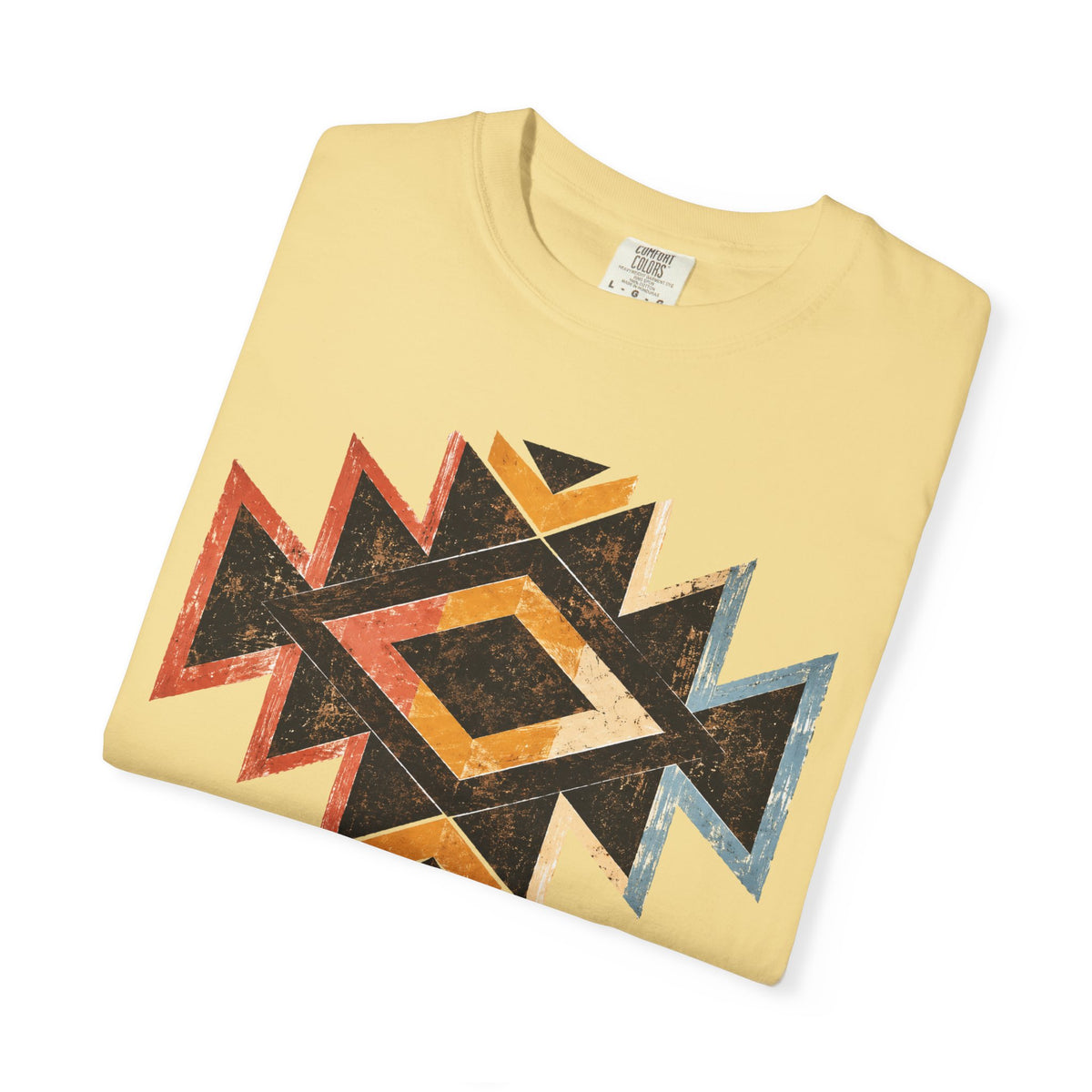 A folded pale yellow t-shirt with a distressed geometric Southwestern-style diamond pattern in black, orange, red, and blue, displayed on a clean white background.