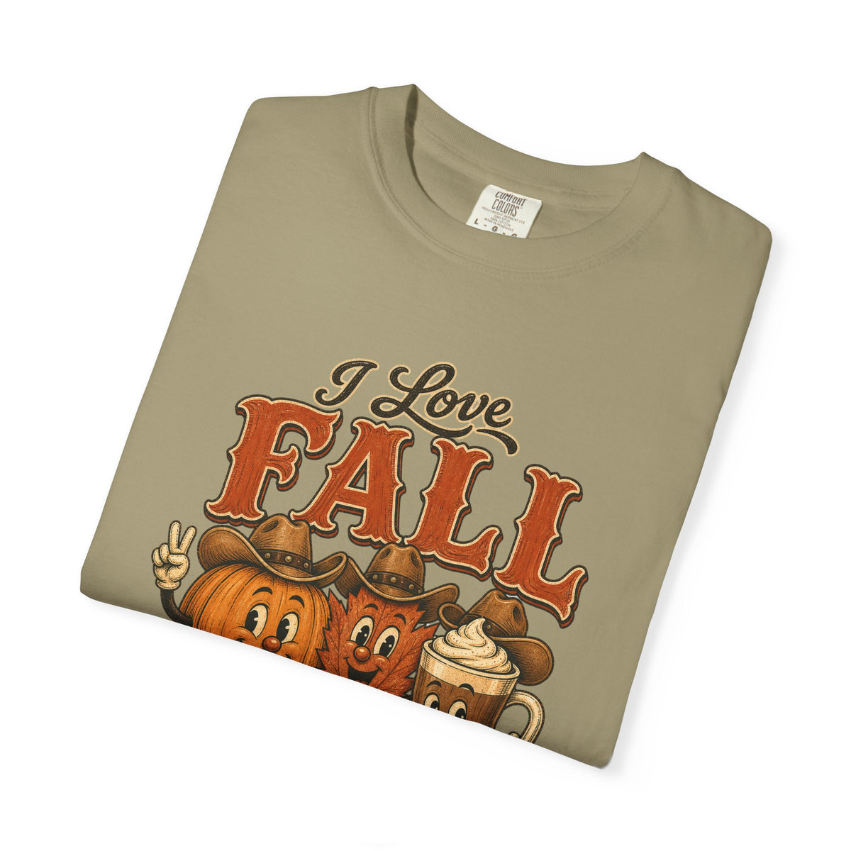 A folded taupe-beige t-shirt with a graphic print that reads 'I Love FALL' in orange and brown lettering, featuring cartoon pumpkins wearing cowboy hats and a hot chocolate mug on a white background.