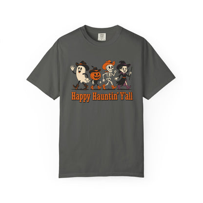 A pepper crewneck t-shirt featuring a cartoon graphic of a ghost, a pumpkin, and a skeleton dancing, with the text 'Happy Haunting' Y'all' printed below in orange.
