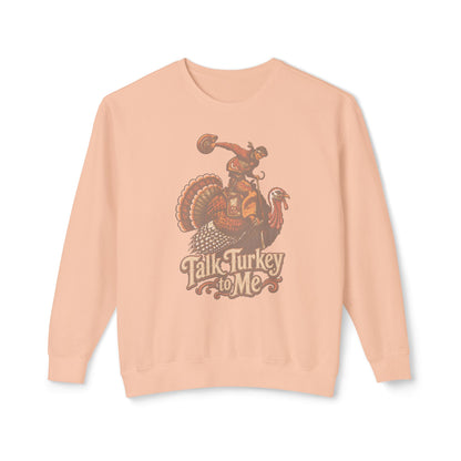A peach-colored crewneck sweatshirt featuring a vintage-style graphic of a turkey riding a horse with the text 'Talk Turkey to Me' printed below, displayed against a clean white background.