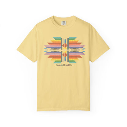 A pale yellow short-sleeve t-shirt with a colorful geometric pattern graphic on the chest and the text 'Brave & Brand Co.' printed below it, displayed on a clean white background.