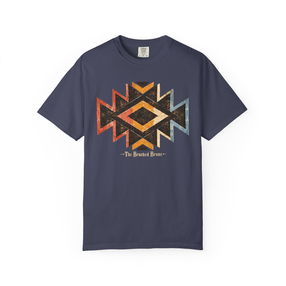 A blue short-sleeve t-shirt with a distressed geometric Southwestern-style diamond graphic in orange, yellow, and light blue, featuring the text 'The Brushed Bronc printed below it.