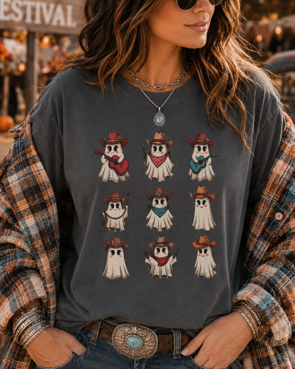 A woman wearing a dark gray graphic t-shirt with a 3x3 grid of cute cartoon ghosts in cowboy hats, styled with an orange and brown plaid flannel shirt, jeans, and a large western-style belt buckle.