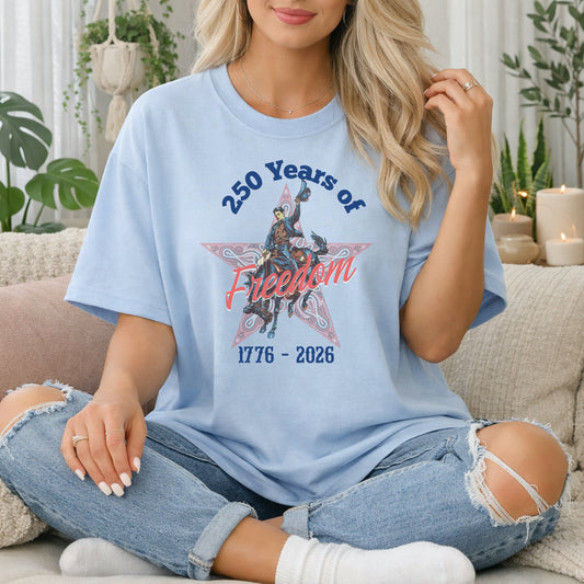 250 Years of Freedom tee with 1776 to 2026 patriotic graphic on model in chambray