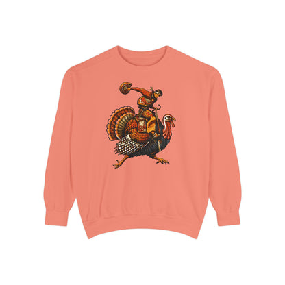 A coral pink crewneck sweatshirt featuring a graphic print of a cowboy riding a turkey, set against a plain white background.
