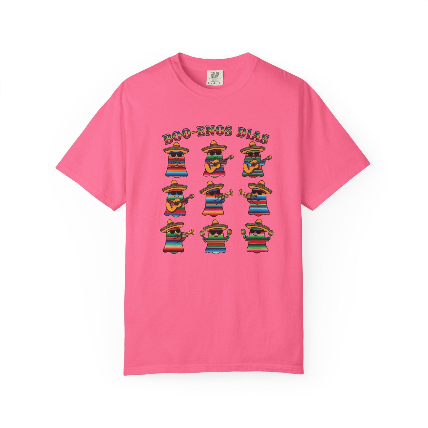 A pink short-sleeve crewneck t-shirt featuring a graphic print of nine cartoon mariachi musicians wearing colorful ponchos and sombrero hats, with the text 'ECO-ZONOS DIAS' above them.