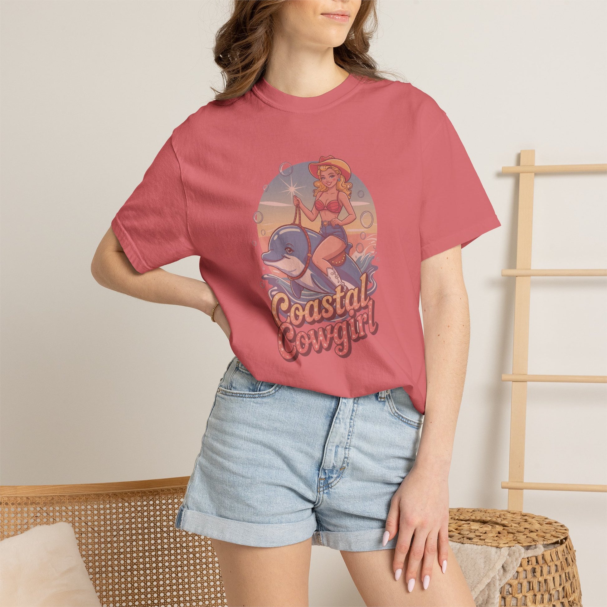 Person wearing a pink t-shirt with 'Coastal Cowgirl' design and denim shorts.