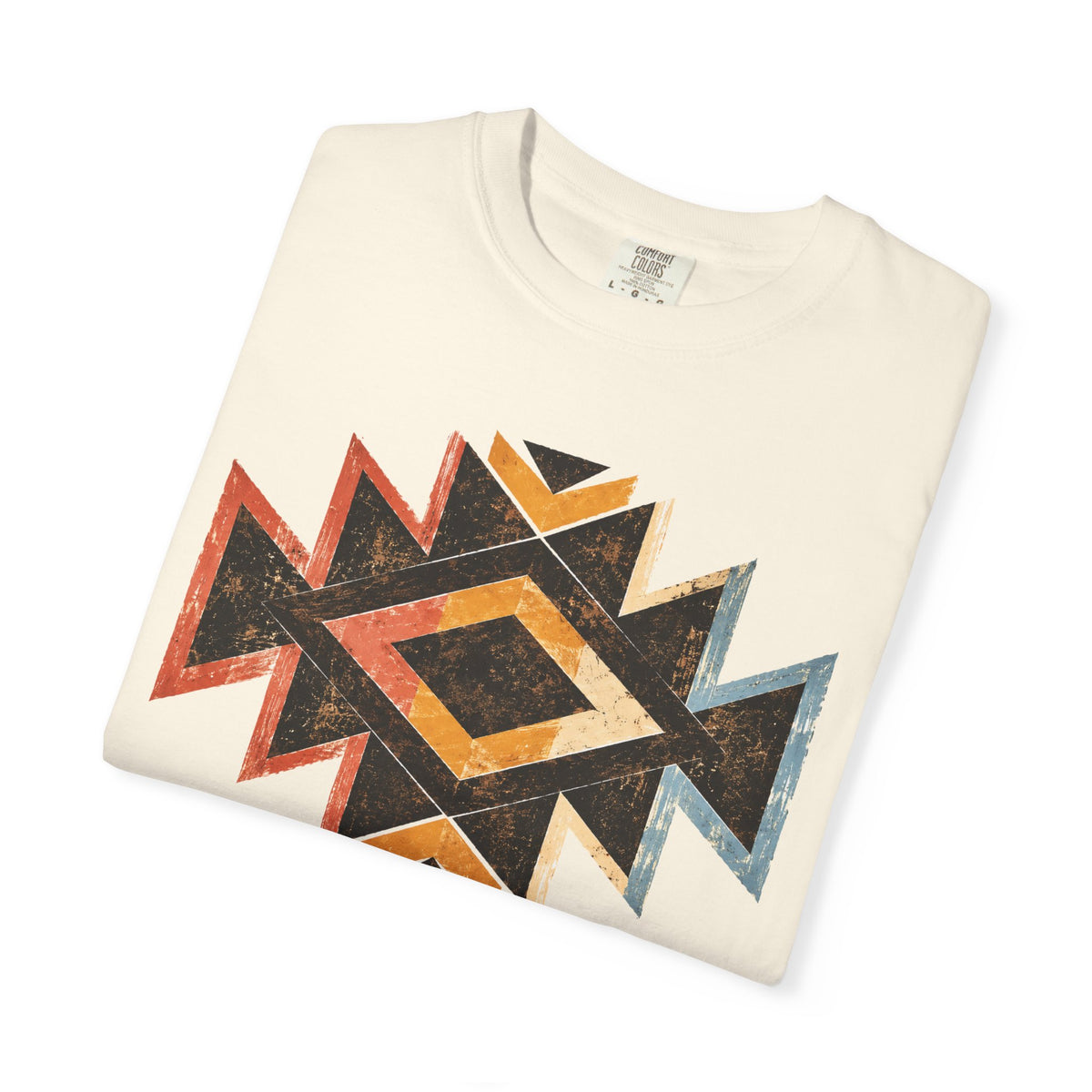 A folded cream-colored t-shirt with a distressed geometric Southwestern-style diamond pattern in black, orange, red, and blue, displayed on a clean white background.