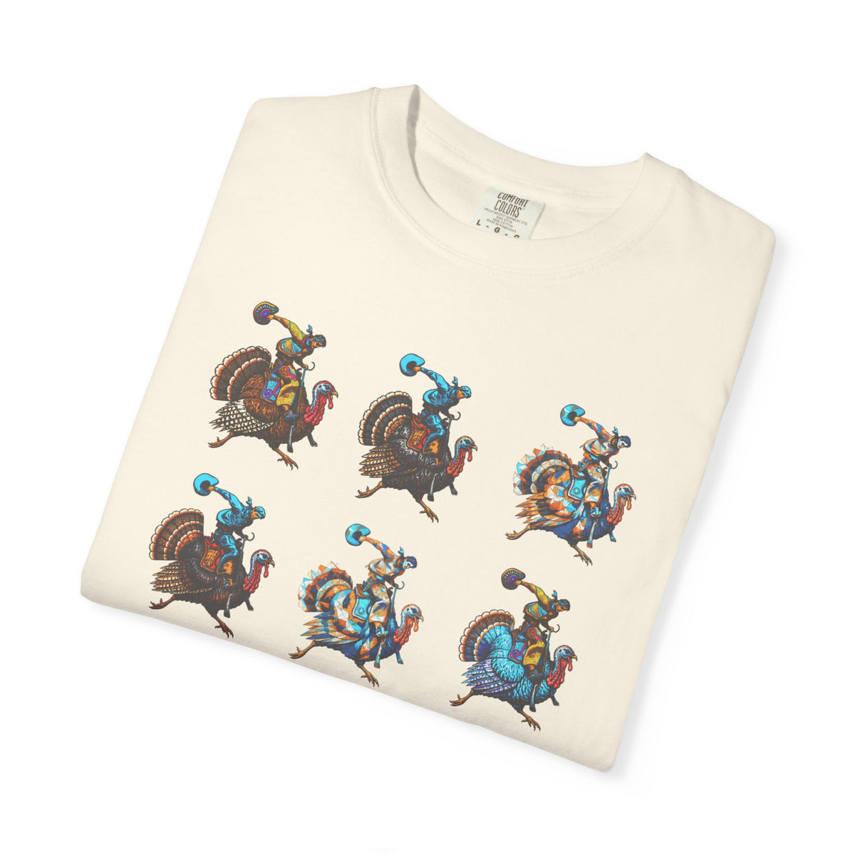 A folded cream-colored t-shirt featuring a graphic print of five stylized cowboy riders on turkeys, displayed on a clean white background.