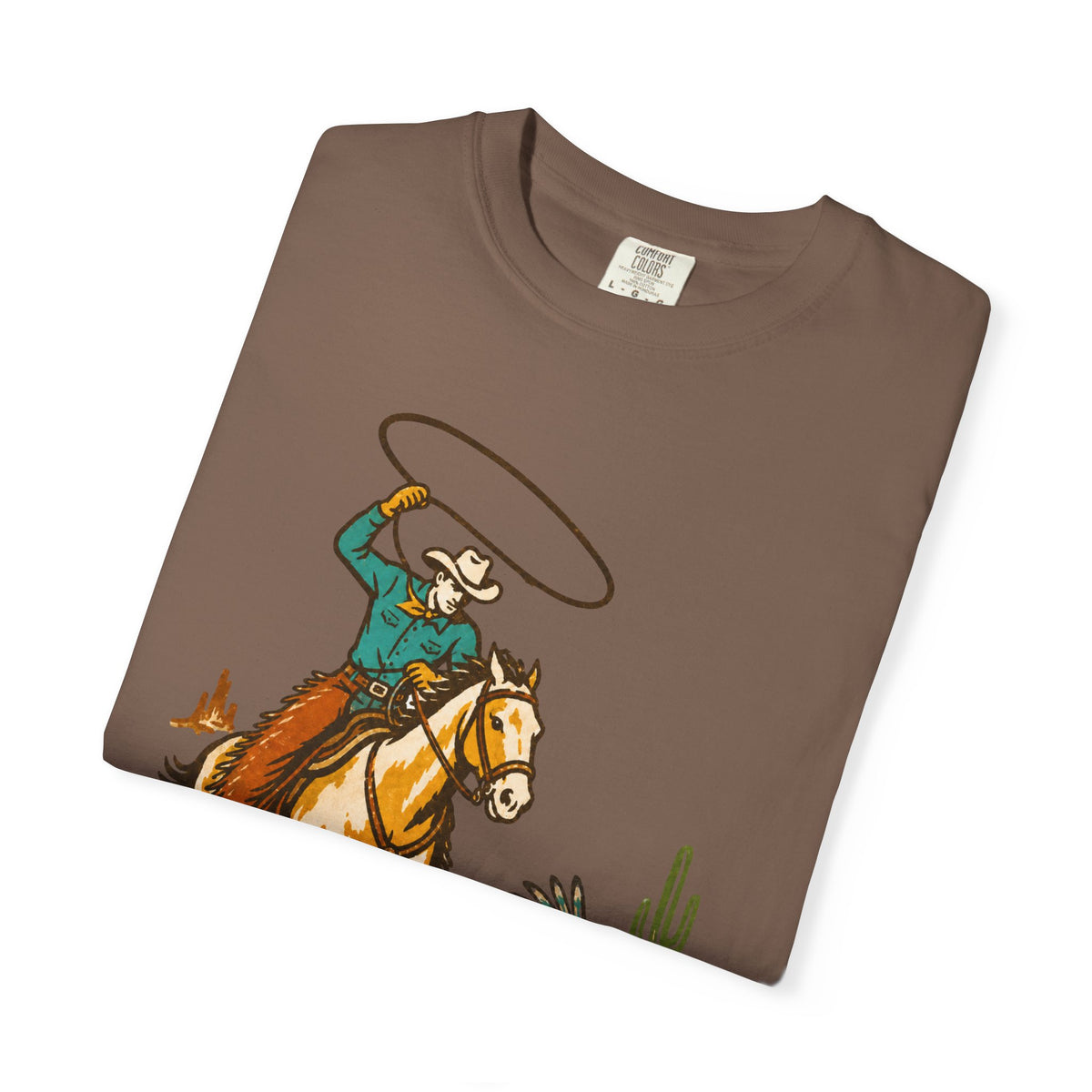 A brown short-sleeve t-shirt with a graphic print of a cowboy on a horse riding west on a desert landscape, shown folded on a white background.