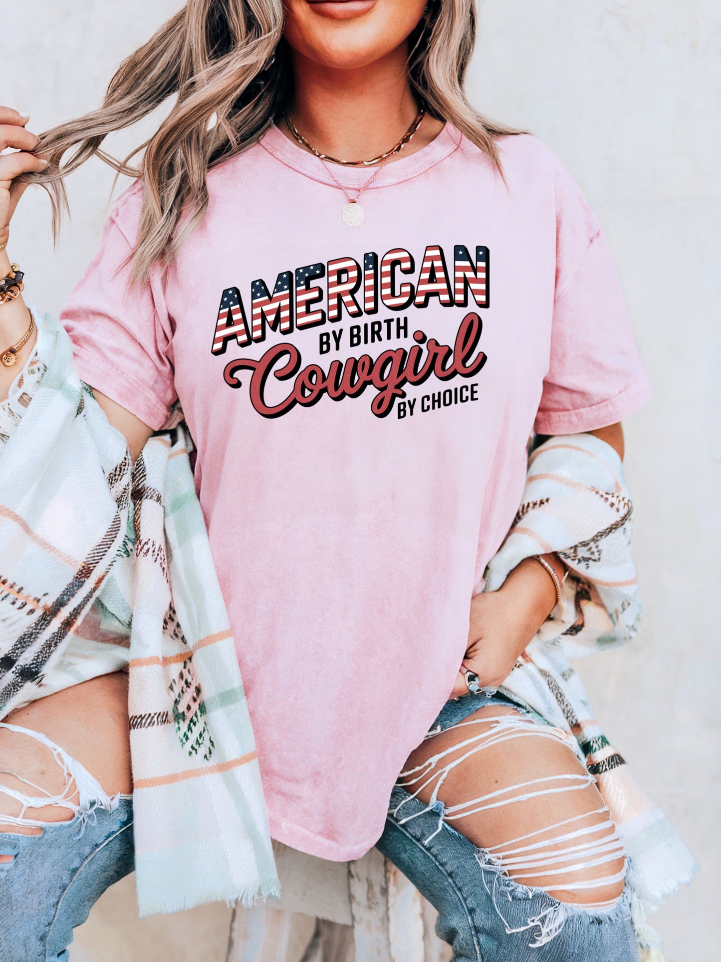 American by Birth Cowgirl by Choice tee with patriotic western lettering on model in color blossom