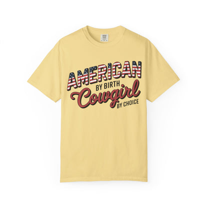 American by Birth Cowgirl by Choice tee with patriotic western lettering laid flat on white background in butter color