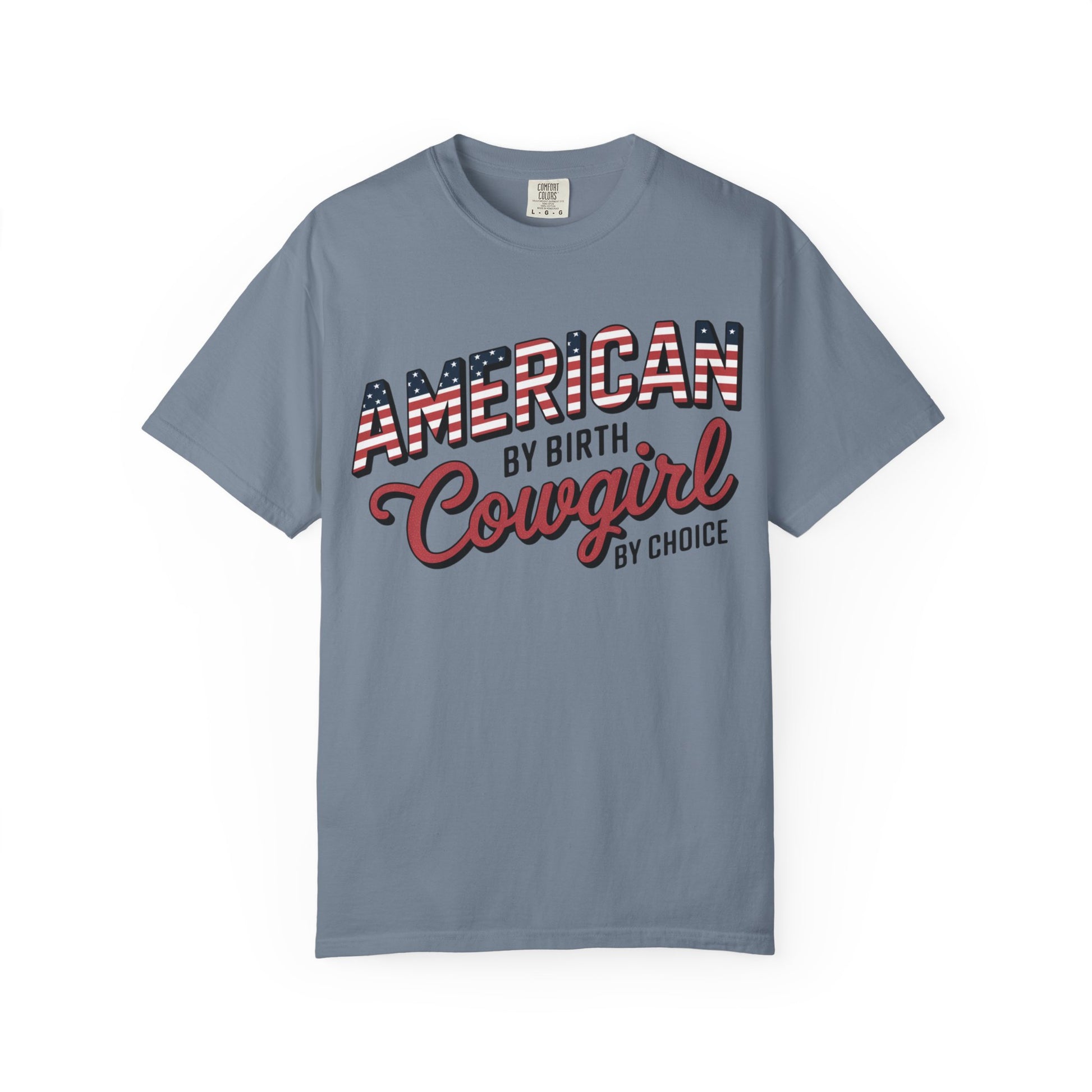 American by Birth Cowgirl by Choice tee with patriotic western lettering laid flat against white background in blue jean color
