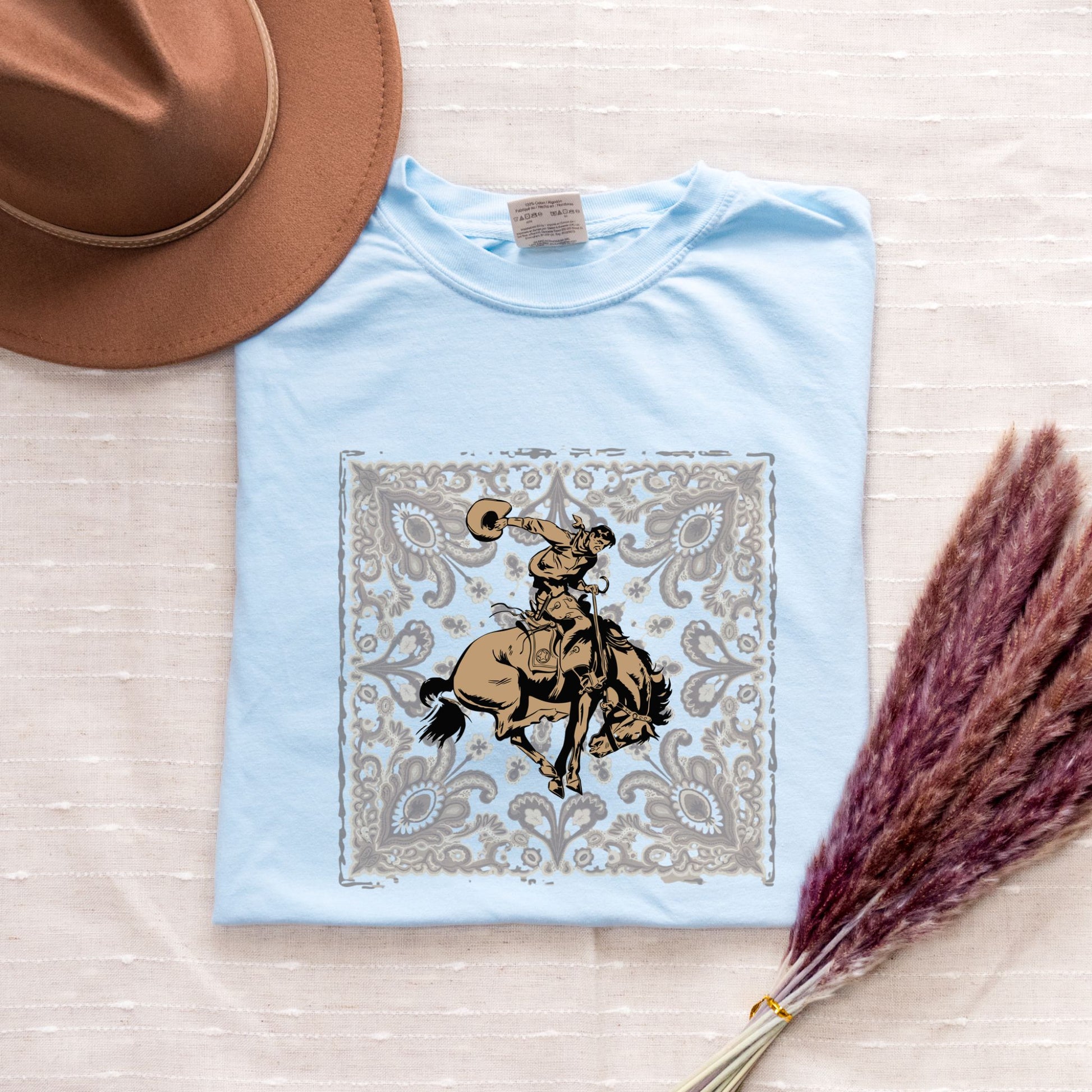 Bandana bronco cowgirl graphic tee laid flat in color chambray