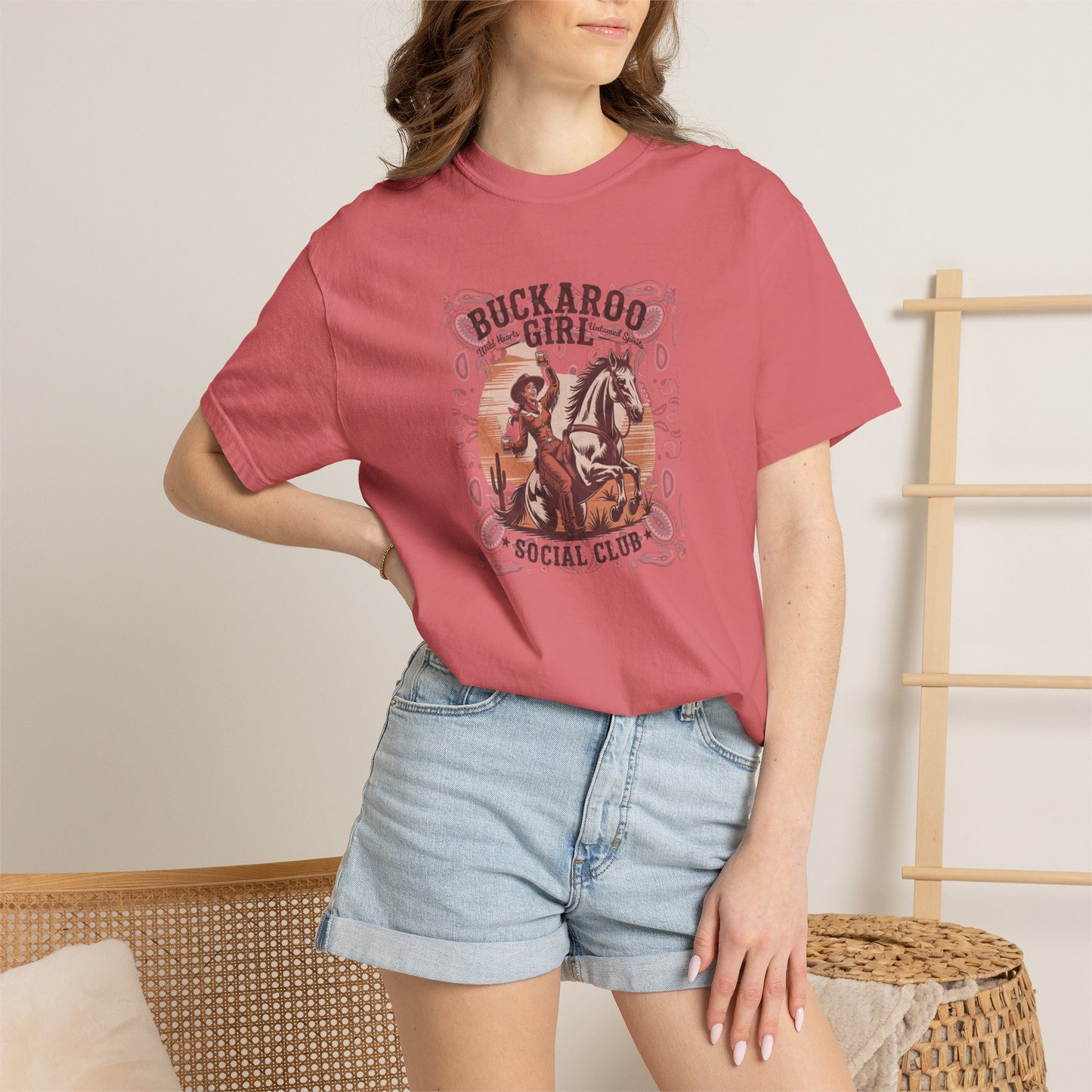 Buckaroo Spirits tee with vintage cowgirl riding horse graphic and western paisley border on model in color watermelon
