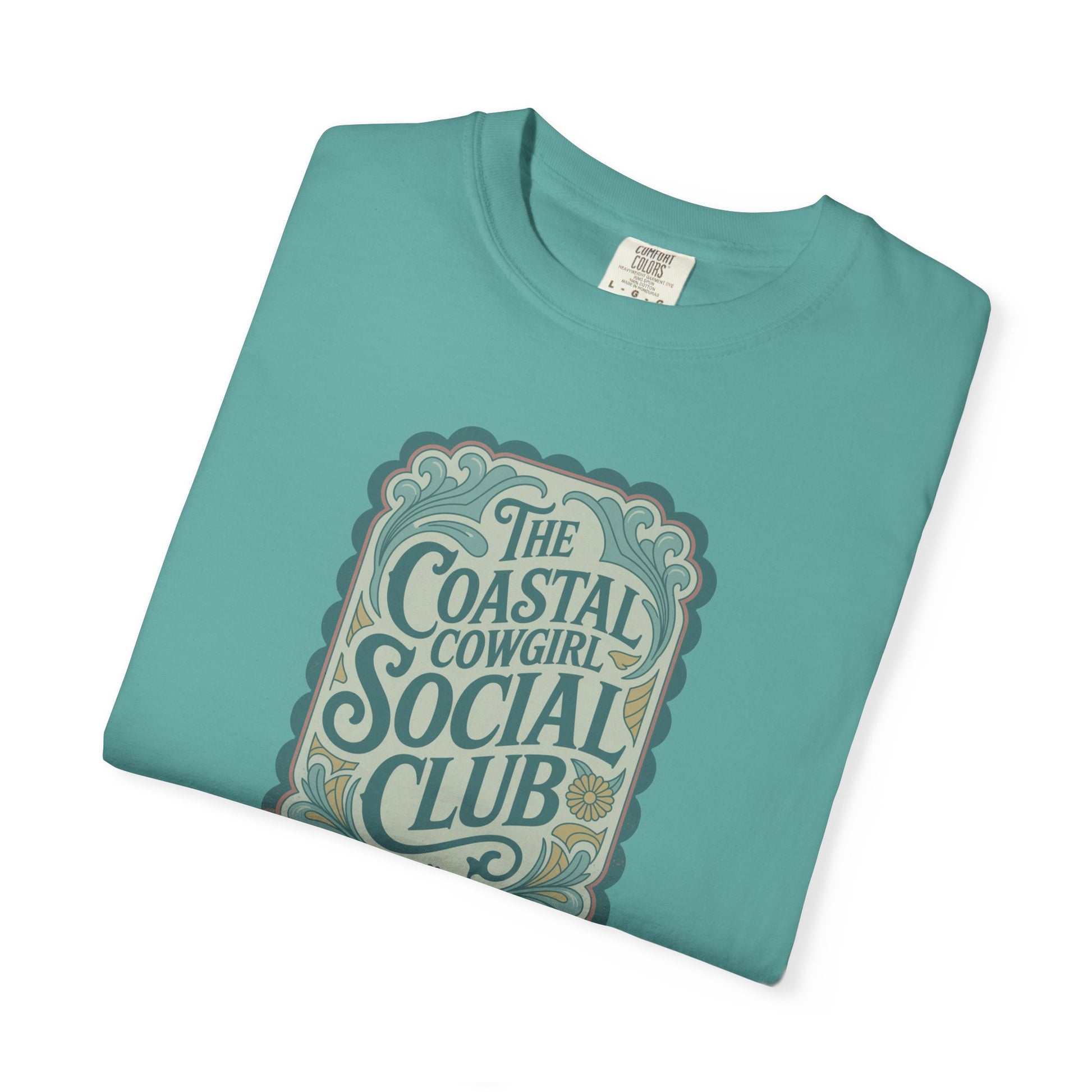Coastal Cowgirl Clubhouse tee with vintage western sign print and retro coastal colours folded in color seafoam