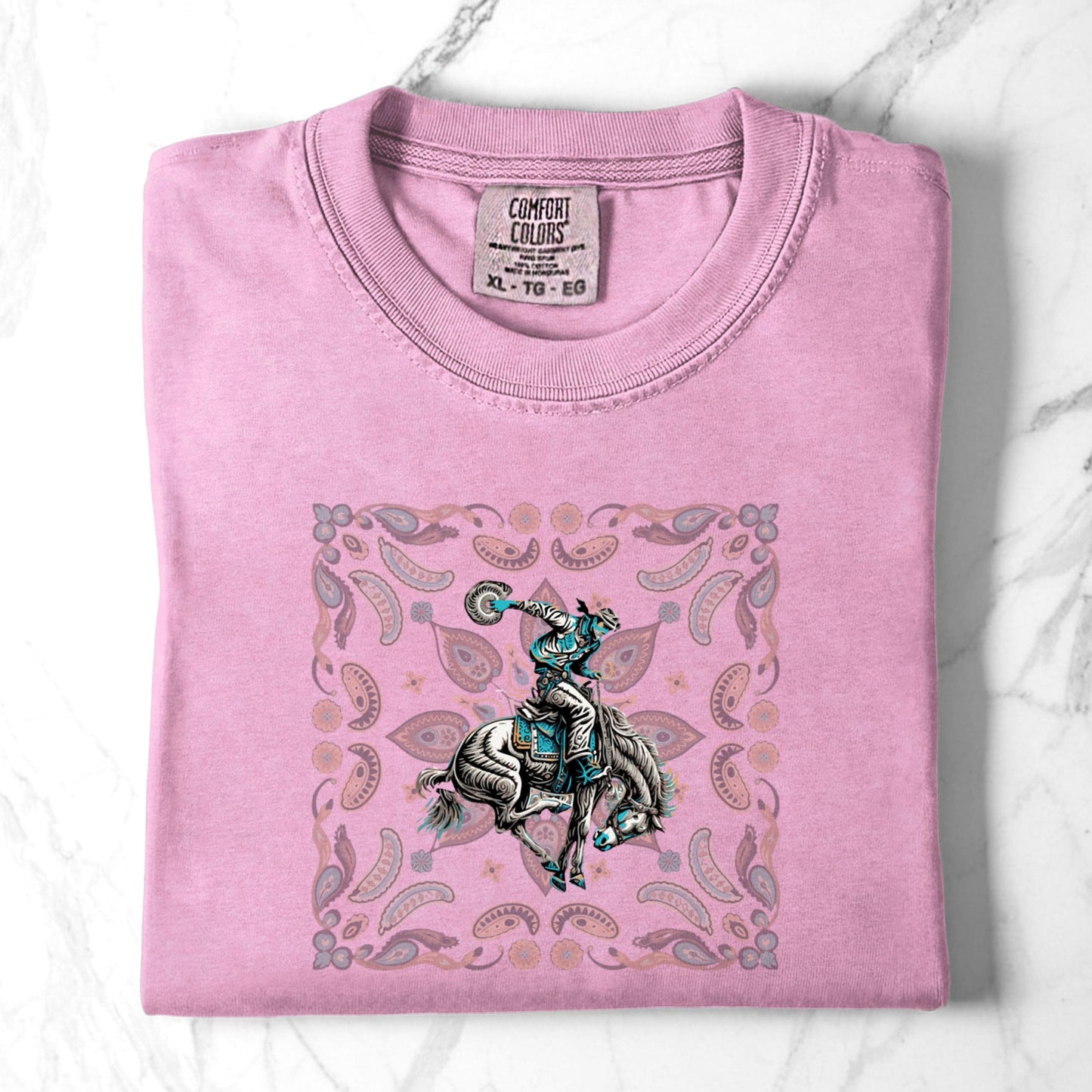 Paisley bronc rider western tee laid flat in color blossom