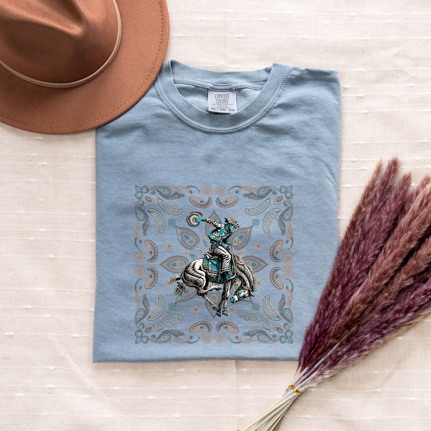 Paisley bronc rider western tee laid flat in color ice blue