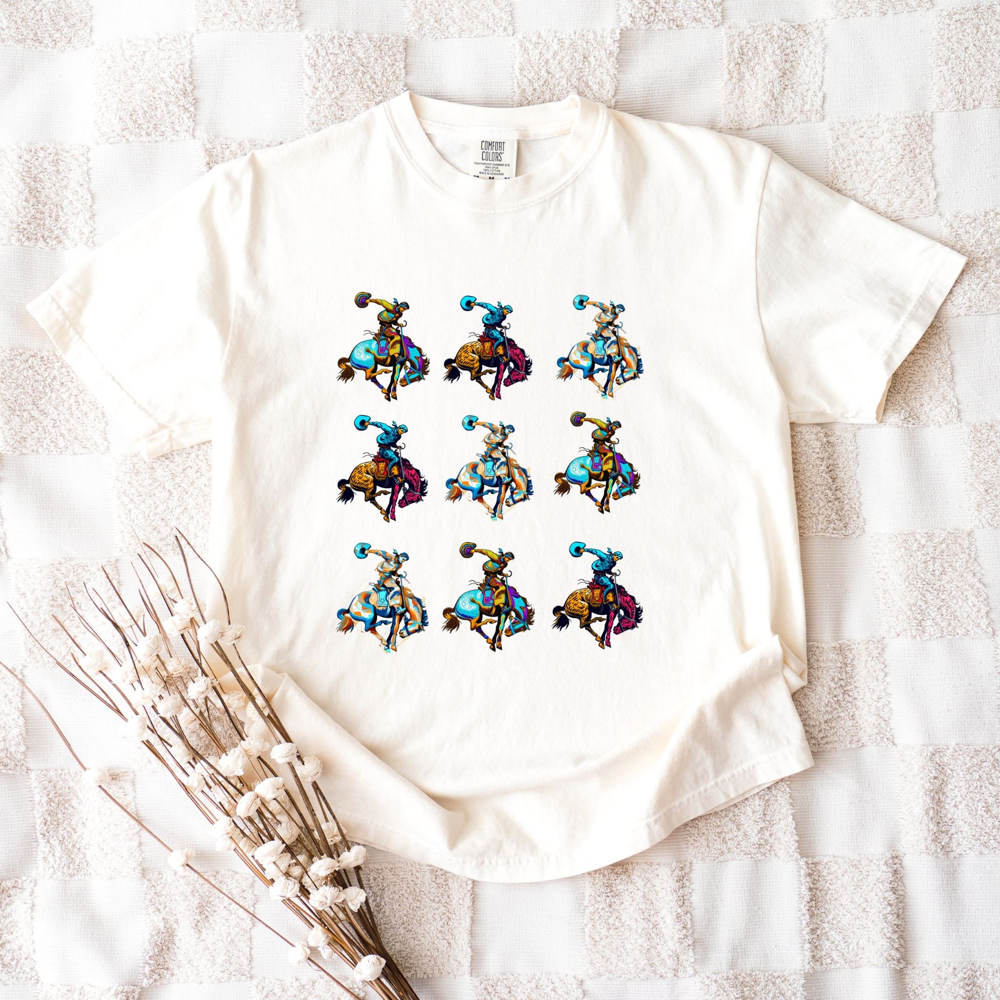 Rodeo Spirit Bronc Rider Grid Tee laid flat in color ivory