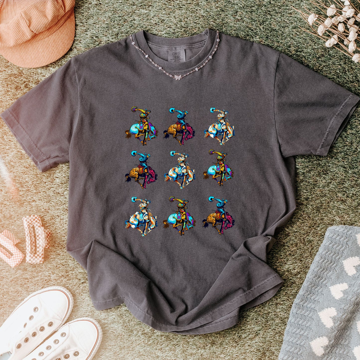 Rodeo Spirit Bronc Rider Grid Tee laid flat in color pepper