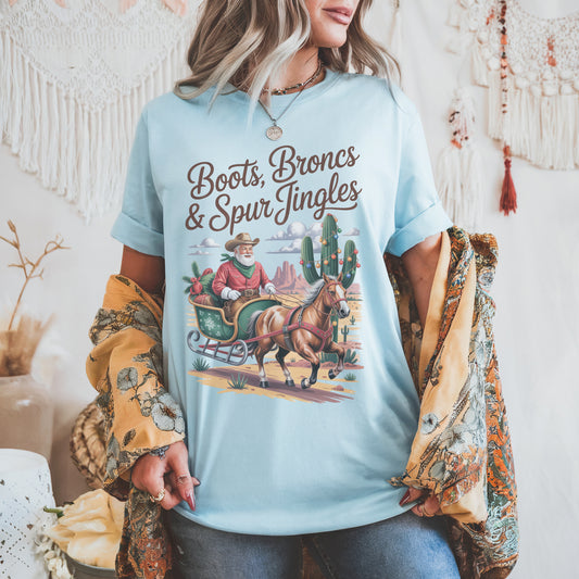 Santa Cowboy Western Christmas t-shirt with Cowboy Santa sleigh, decorated cacti, and desert sunset design