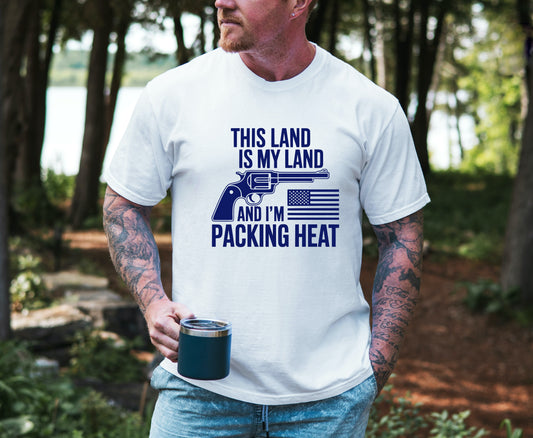 Man wearing a white bronc and brand co patriotic t-shirt with a graphic and text in a forest setting