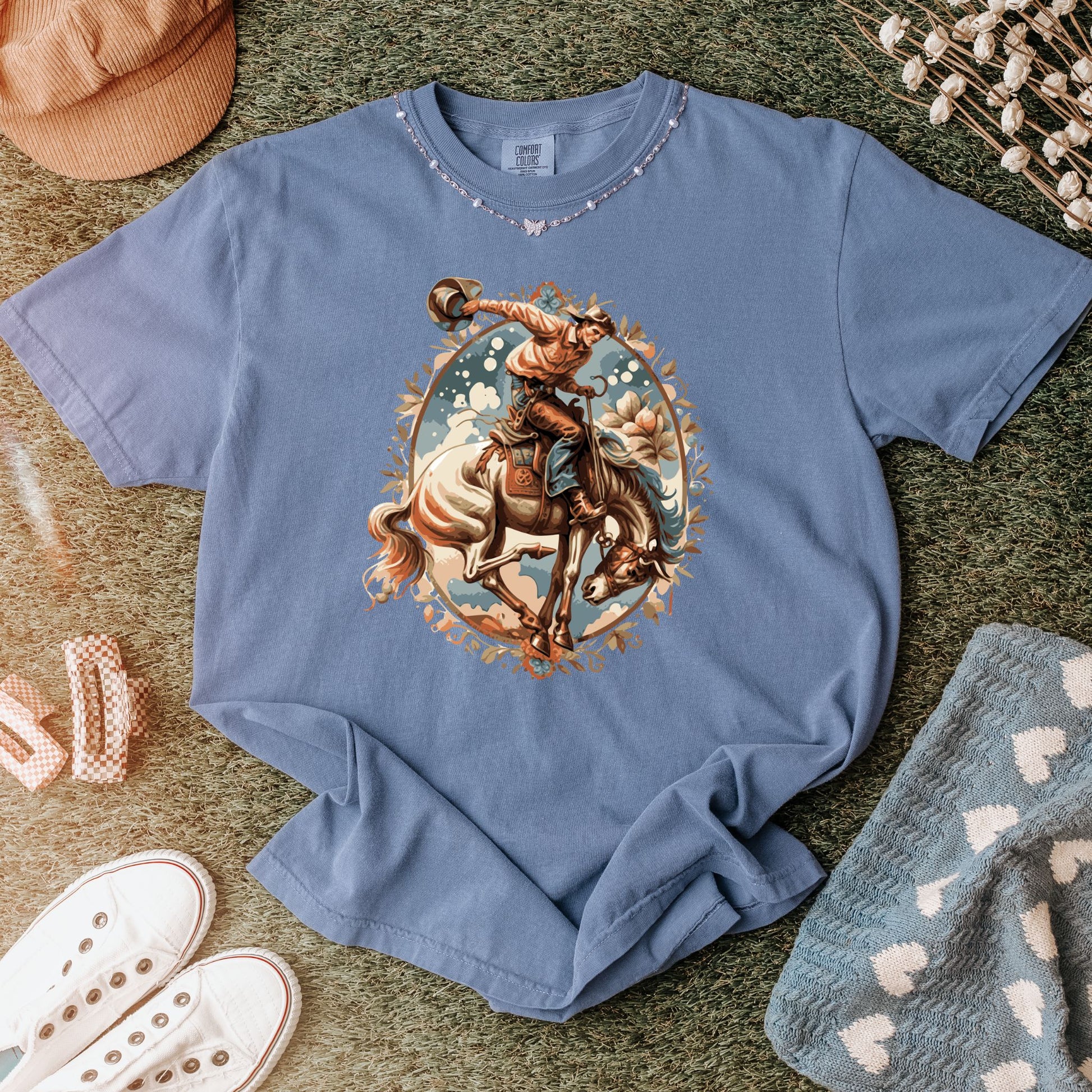 Vintage floral cowgirl tee laid out with props in color blue jean
